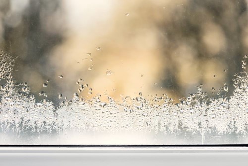 Close-up of a window with condensation due to cold weather outside.